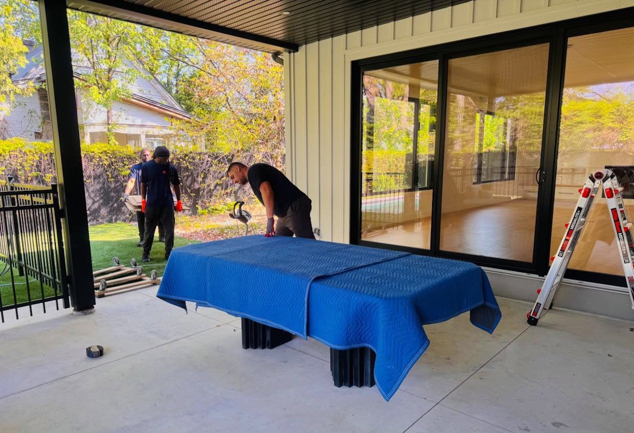 Équipe protégeant un meuble sous couverture devant une maison